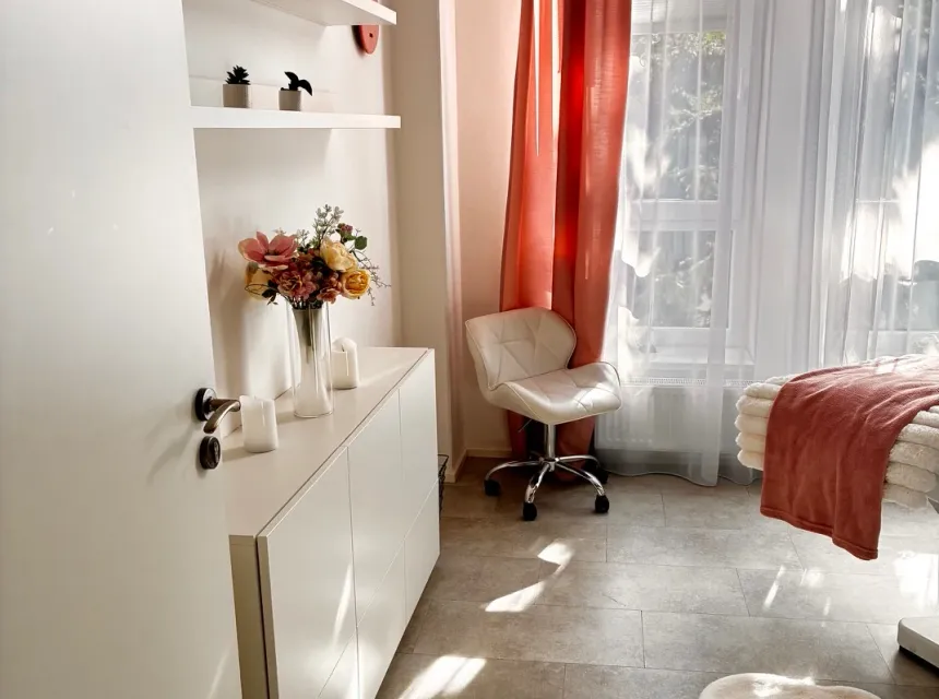 The massage room at Studio Natur Look in Kunratice — sunlight, the massage table and a white cabinet